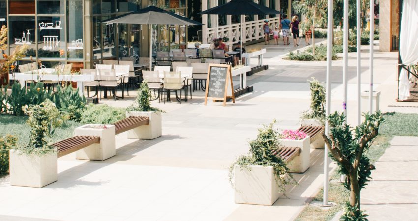 eine moderne Fußgängerzone mit angrenzendem Café im Sommer