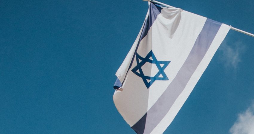 Eine israelische Flagge weht im Wind, im Hintergrund blauer Himmel