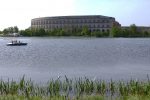 Die Kongresshalle Nürnberg, im Vordergrund der Dutzendteich und eine Gruppe Menschen in einem Tretboot.