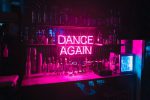 Bar mit pinker Leuchtschrift "Dance again"