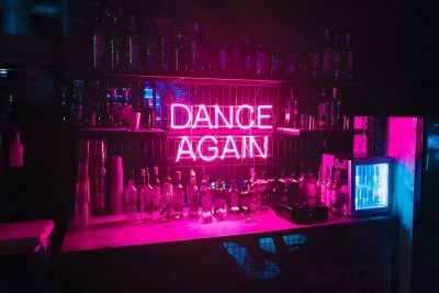 Bar mit pinker Leuchtschrift "Dance again"