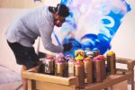 Graffity-Sprayer mit Gasmaske, der ein Bild sprayt