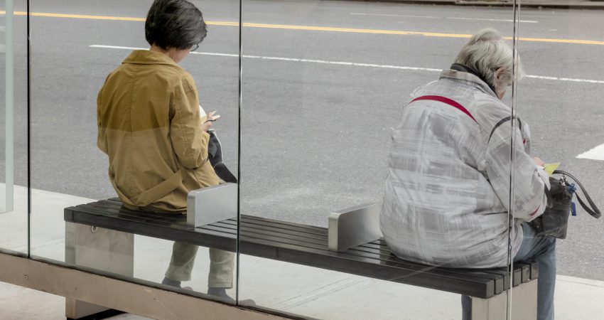 Zwei Frauen warten in einer Bushaltestelle