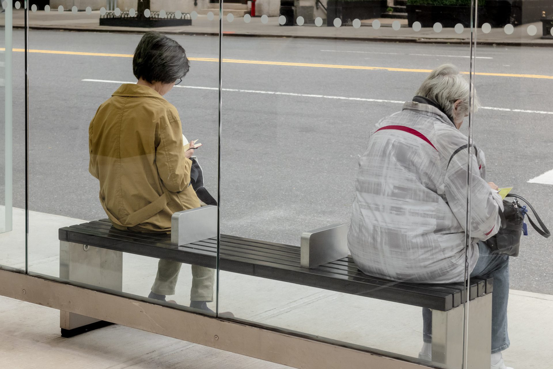 Zwei Frauen warten in einer Bushaltestelle