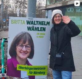 Britta Walthelm vor einem Wahlplakat