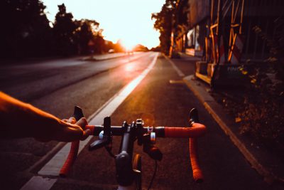 Fahrradfahrer:in auf Rennrad fährt in Sonnenuntergang