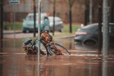 Fahrrad an Laternenmast, das in einer überfluteten Straße steht