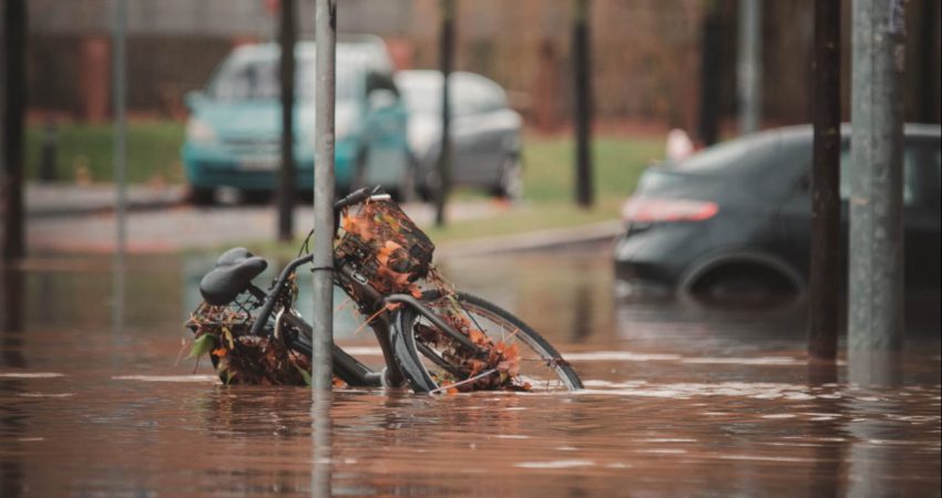 Fahrrad an Laternenmast, das in einer überfluteten Straße steht