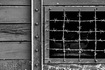 Vergittertes Fenster von Barracke in schwarz-weiß