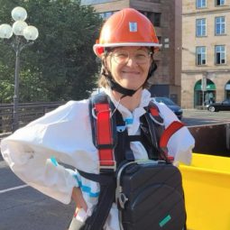 Britta Walthelm in Schutzkleidung für die Kanalinspektion, im Hintergrund das Opernhaus Nürnberg.