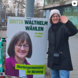 Britta Walthelm vor einem Wahlplakat