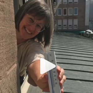 Britta Walthelm mit Thermometer, der hohe Temperaturen anzeigt.