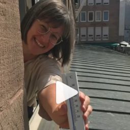 Britta Walthelm mit Thermometer, der hohe Temperaturen anzeigt.